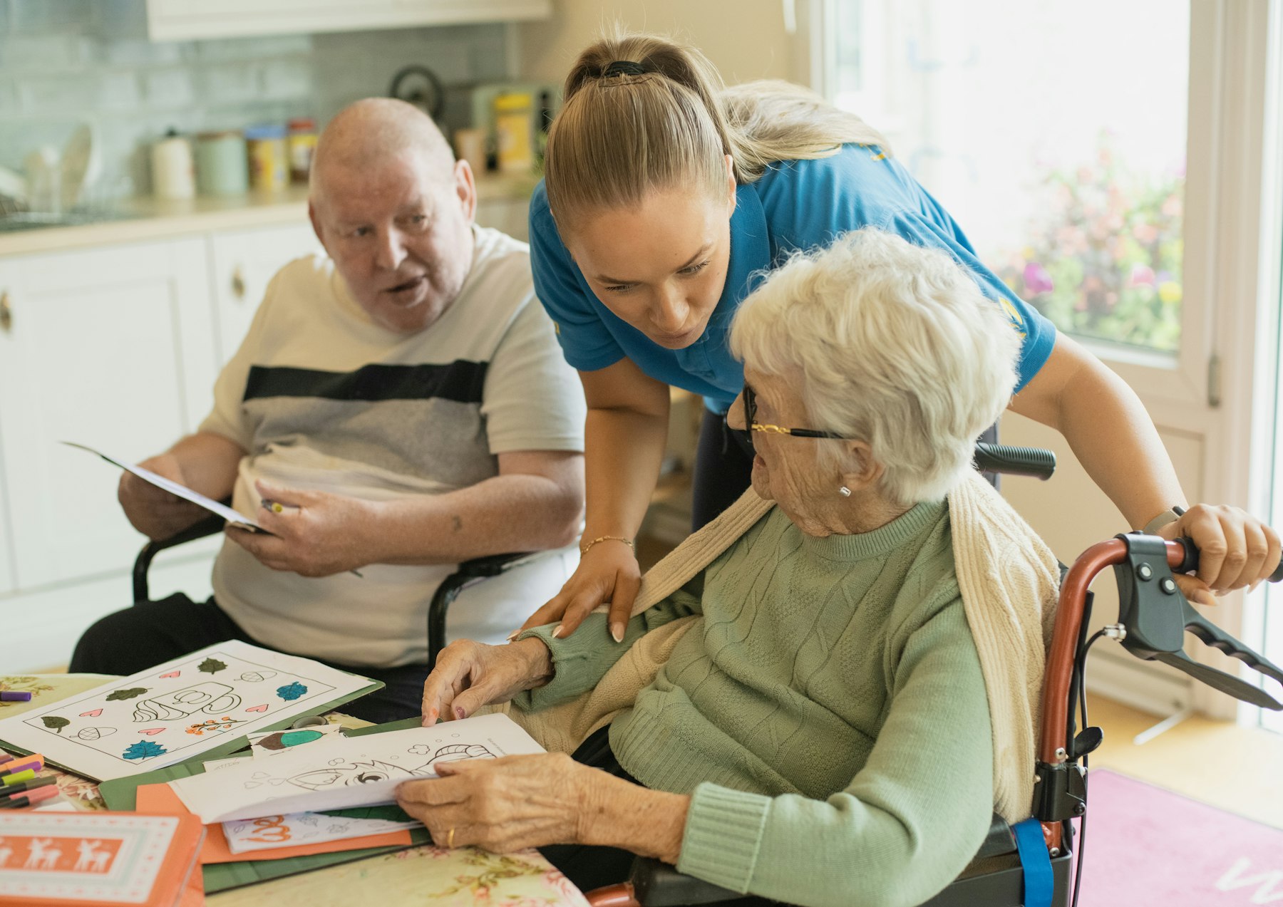 Care worker supporting older people with an activity at home